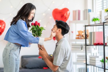 Asian couple Showing love surprise giving flowers or gifts to each other on important occasions such Valentine's Day birthdays or wedding anniversaries with love and warmth in bedroom of their home