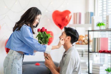 Asian couple Showing love surprise giving flowers or gifts to each other on important occasions such Valentine's Day birthdays or wedding anniversaries with love and warmth in bedroom of their home