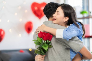 Asian couple Showing love surprise giving flowers or gifts to each other on important occasions such Valentine's Day birthdays or wedding anniversaries with love and warmth in bedroom of their home