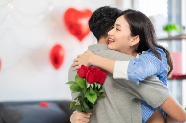 Asian couple Showing love surprise giving flowers or gifts to each other on important occasions such Valentine's Day birthdays or wedding anniversaries with love and warmth in bedroom of their home
