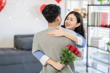 Asian couple Showing love surprise giving flowers or gifts to each other on important occasions such Valentine's Day birthdays or wedding anniversaries with love and warmth in bedroom of their home