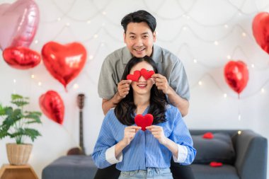 Asian couple Showing love surprise giving flowers or gifts to each other on important occasions such Valentine's Day birthdays or wedding anniversaries with love and warmth in bedroom of their home