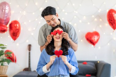Asian couple Showing love surprise giving flowers or gifts to each other on important occasions such Valentine's Day birthdays or wedding anniversaries with love and warmth in bedroom of their home