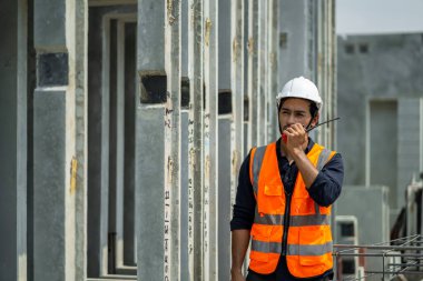 Erkek mühendisler, çalışanların çalışmalarını ve üretilmiş ürünlerin kalitesini standartlara uygun şekilde inceleyip kontrol ediyorlar. Prefabrik duvarlar üreten endüstriyel fabrikalarda