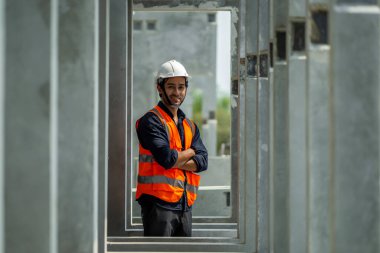 Erkek mühendisler, çalışanların çalışmalarını ve üretilmiş ürünlerin kalitesini standartlara uygun şekilde inceleyip kontrol ediyorlar. Prefabrik duvarlar üreten endüstriyel fabrikalarda