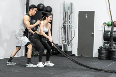 Asian men and women Have a strong body, good health, love to exercise. They are exercising together at the gym having fun.	