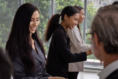 Çok ırklı iş adamlarından oluşan bir grup, işi ilerletmek için beyin fırtınası yapmak üzere bir araya geldi..