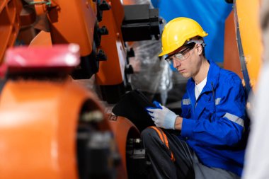 Bir grup mühendis bilgisayar kontrollü çelik kaynaklama robotlarını incelemek için toplanıyor. Provalar ve kullanım için kurulum planı.