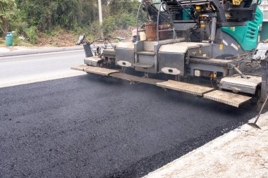 Arabalara yol yapmak için makineler asfalt döküyor..