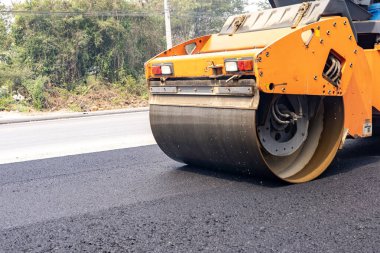 Arabalara yol yapmak için bardaktan boşalırcasına makineler asfaltı eziyor..