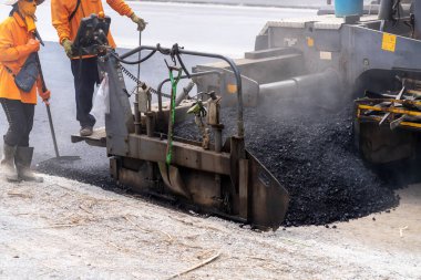 Arabalara yol yapmak için makineler asfalt döküyor..