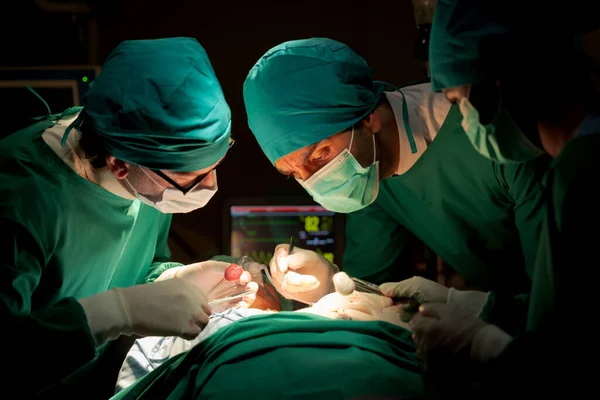 Team doctors operating room dressed green uniforms saving lives critically patient undergoing heart surgery for heart patients There standardized surgical tools life-saving tool such heart pumps