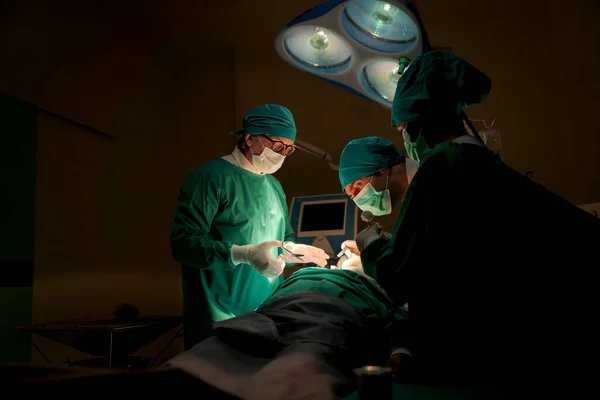 Team doctors operating room dressed green uniforms saving lives critically patient undergoing heart surgery for heart patients There standardized surgical tools life-saving tool such heart pumps
