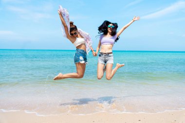 LGBTQ lesbian couple on the beach The couple went to the sea on vacation together happily.