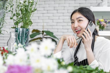 Bir grup kadın çiçekçi, düğün, sevgililer günü ya da sevdiklerine vermek gibi çeşitli törenler için gelen müşteriler için çiçek düzenliyor..