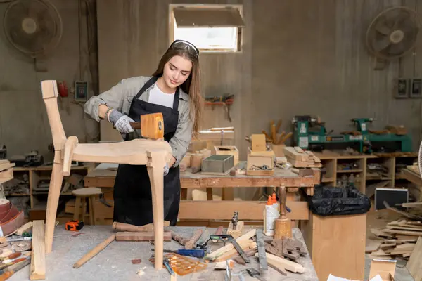 彼女が設計し建設した椅子を組み立てた女性大工 家の中に見つかった家具工場で — ストック写真