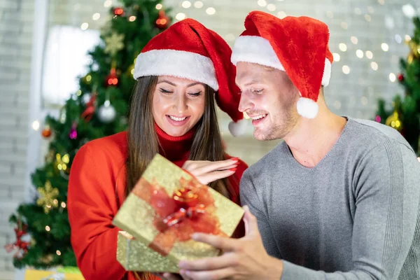 一对年轻夫妇在家里快乐地庆祝他们的圣诞 — 图库照片