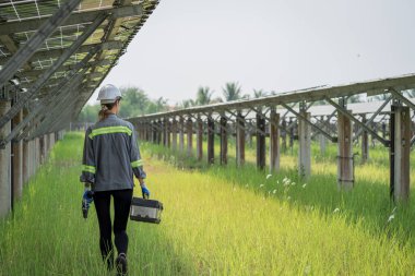 Güneş enerjisi tarlasında büyük yapı kontrolüne sahip elektrik mühendisi profesyonel hayatı boyunca maksimum verimlilikle elektrik üretmek için hasarlı parçaların kullanımını sürdürüyor.