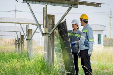 Güneş enerjisi tarlasında büyük yapı kontrolüne sahip elektrik mühendisi profesyonel hayatı boyunca maksimum verimlilikle elektrik üretmek için hasarlı parçaların kullanımını sürdürüyor.