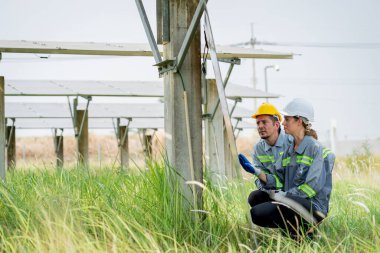 Güneş enerjisi tarlasında büyük yapı kontrolüne sahip elektrik mühendisi profesyonel hayatı boyunca maksimum verimlilikle elektrik üretmek için hasarlı parçaların kullanımını sürdürüyor.