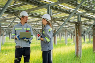 Güneş enerjisi tarlasında büyük yapı kontrolüne sahip elektrik mühendisi profesyonel hayatı boyunca maksimum verimlilikle elektrik üretmek için hasarlı parçaların kullanımını sürdürüyor.