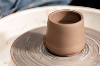 Toprak kaplama. Çamur yontma sanatı. Seramik el ile şekillendiriliyor. Profesyonel olarak bir tabak ya da vazo yaratmak için doğru duruş ile