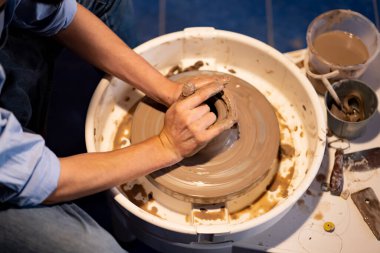 Toprak kaplama. Çamur yontma sanatı. Seramik el ile şekillendiriliyor. Profesyonel olarak bir tabak ya da vazo yaratmak için doğru duruş ile