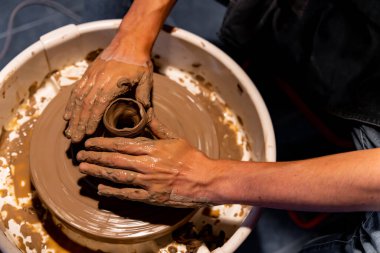 Toprak kaplama. Çamur yontma sanatı. Seramik el ile şekillendiriliyor. Profesyonel olarak bir tabak ya da vazo yaratmak için doğru duruş ile