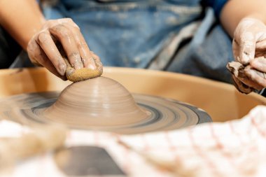 Toprak kaplama. Çamur yontma sanatı. Seramik el ile şekillendiriliyor. Profesyonel olarak bir tabak ya da vazo yaratmak için doğru duruş ile