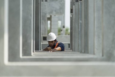 Male engineers are inspecting and controlling the work of the employees and the quality of the manufactured products to meet the standards In industrial factories producing precast prefabricated walls