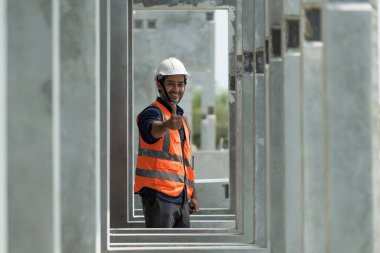 Male engineers are inspecting and controlling the work of the employees and the quality of the manufactured products to meet the standards In industrial factories producing precast prefabricated walls