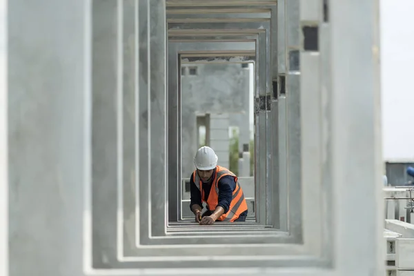 Male engineers are inspecting and controlling the work of the employees and the quality of the manufactured products to meet the standards In industrial factories producing precast prefabricated walls