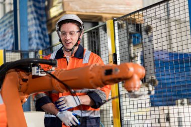 Bir grup erkek mühendis bilgisayar kontrollü çelik kaynaklama robotlarını incelemek için buluşuyor. Provalar ve kullanım için kurulum planı.