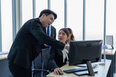 Bir grup Asyalı genç iş adamı mutlu mesut konuşup eğleniyor. Şirketin ofisinde.