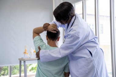 Kadın doktor ve erkek hasta. Hastanede fizik tedavi yapılıyor..