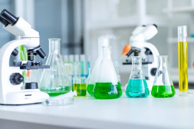 Bir mikroskop ve bir sürü test tüpü içeriyor. Okuldaki laboratuvarda. 