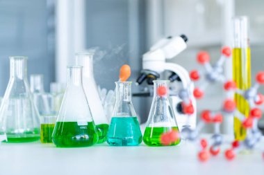 Bir mikroskop ve bir sürü test tüpü içeriyor. Okuldaki laboratuvarda. 