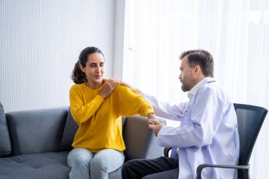 Erkek doktor ve kadın hasta konuşuyor ve hastanedeki hastaların hastalıkları hakkında tavsiyelerde bulunuyor.