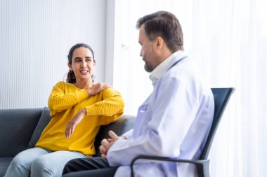 Erkek doktor ve kadın hasta konuşuyor ve hastanedeki hastaların hastalıkları hakkında tavsiyelerde bulunuyor.