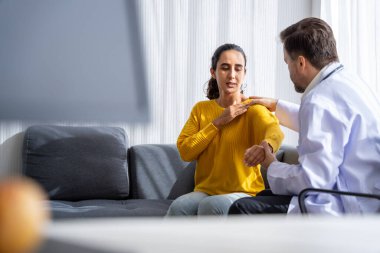 Erkek doktor ve kadın hasta konuşuyor ve hastanedeki hastaların hastalıkları hakkında tavsiyelerde bulunuyor.