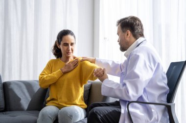 Erkek doktor ve kadın hasta konuşuyor ve hastanedeki hastaların hastalıkları hakkında tavsiyelerde bulunuyor.