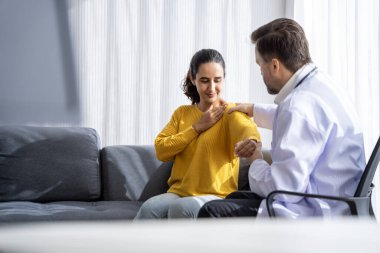 Erkek doktor ve kadın hasta konuşuyor ve hastanedeki hastaların hastalıkları hakkında tavsiyelerde bulunuyor.