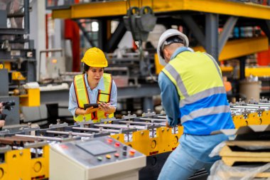 Metal levha fabrikasında çalışan genç erkek ve kadın mühendislerden oluşan bir ekip gerçek şantiyede denetleniyor. Profesyonel ve mutlu çalışın.