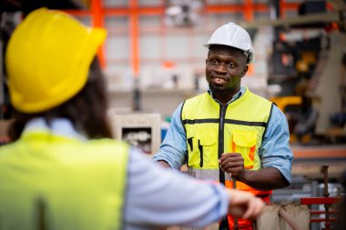 Metal levha fabrikasında çalışan genç erkek mühendis gerçek şantiyede denetleniyor. Profesyonel ve mutlu çalışın.