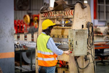 Metal levha fabrikasında çalışan genç bayan mühendis gerçek şantiyede denetleniyor. Profesyonel ve mutlu çalışın.