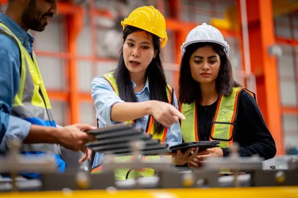 Team of young male and female engineers in a metal sheet factory Responsible work is being inspected at the actual work site. Work professionally and happily