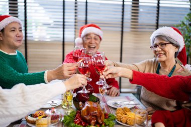 Noel günü Asyalı bir aile. Hediye ve turuncu ışıklarla dolu Noel temalı bir odada herkes mutlu..