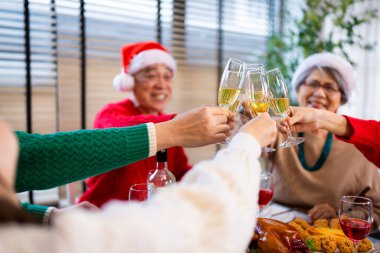 Noel günü Asyalı bir aile. Hediye ve turuncu ışıklarla dolu Noel temalı bir odada herkes mutlu..