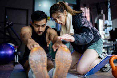 Asian man and woman working out, one is a trainer, the other is an exerciser.	