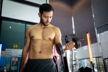 A strong Asian man is exercising to build muscle.	